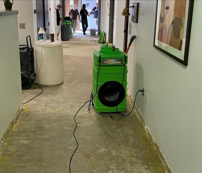 Commercial hallway with flooring removed and drying equipment set