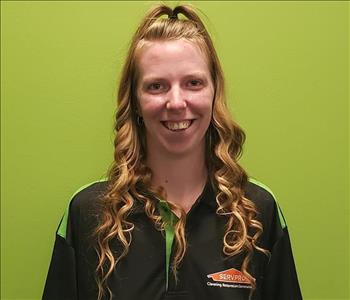Woman in a SERVPRO uniform on a green background
