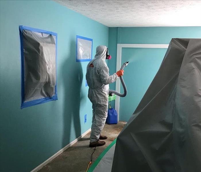 Man cleaning and fogging a commercial property for microbial growth