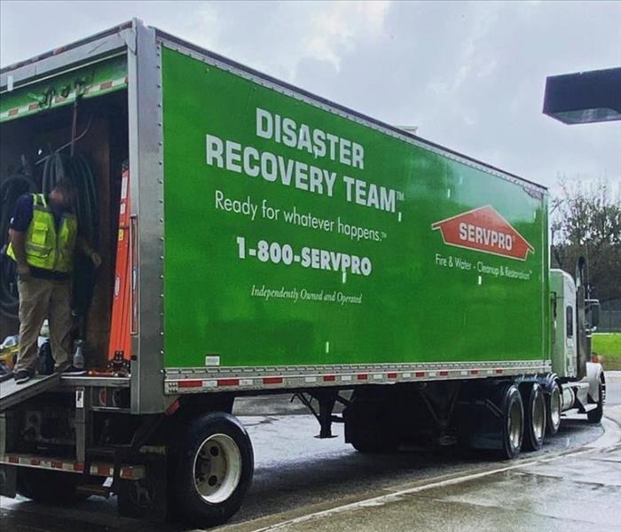 Man on the back of a disaster recovery SERVPRO truck