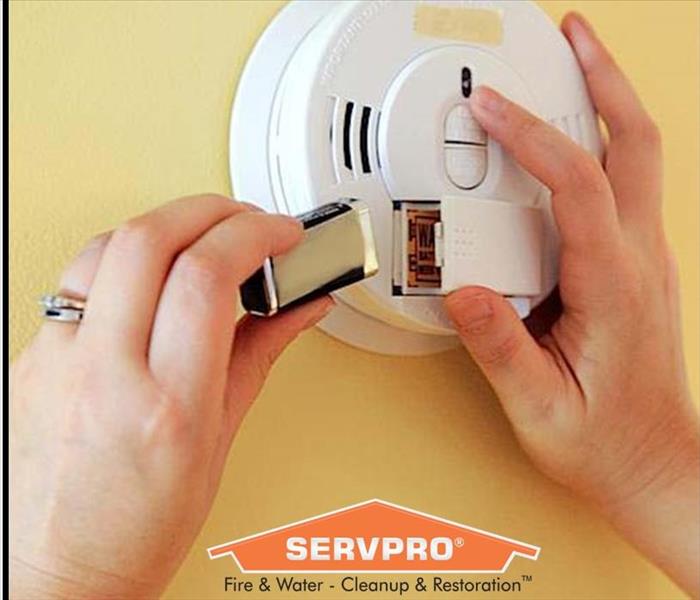 Person Replacing Batteries In a Smoke Alarm